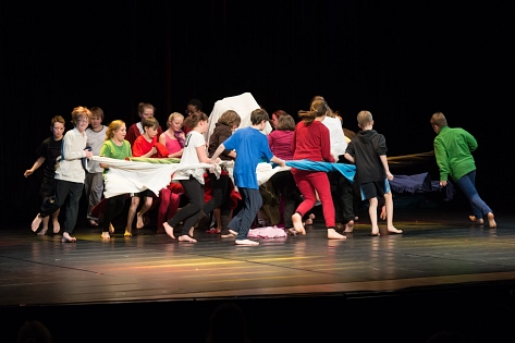 Hier würden sie ein Bild der Aufführung Tanz macht Schule sehen. Eine Gruppe von Schüler:innen tanzen mit Tüchern auf der Bühne © Tintenklecks e.V.